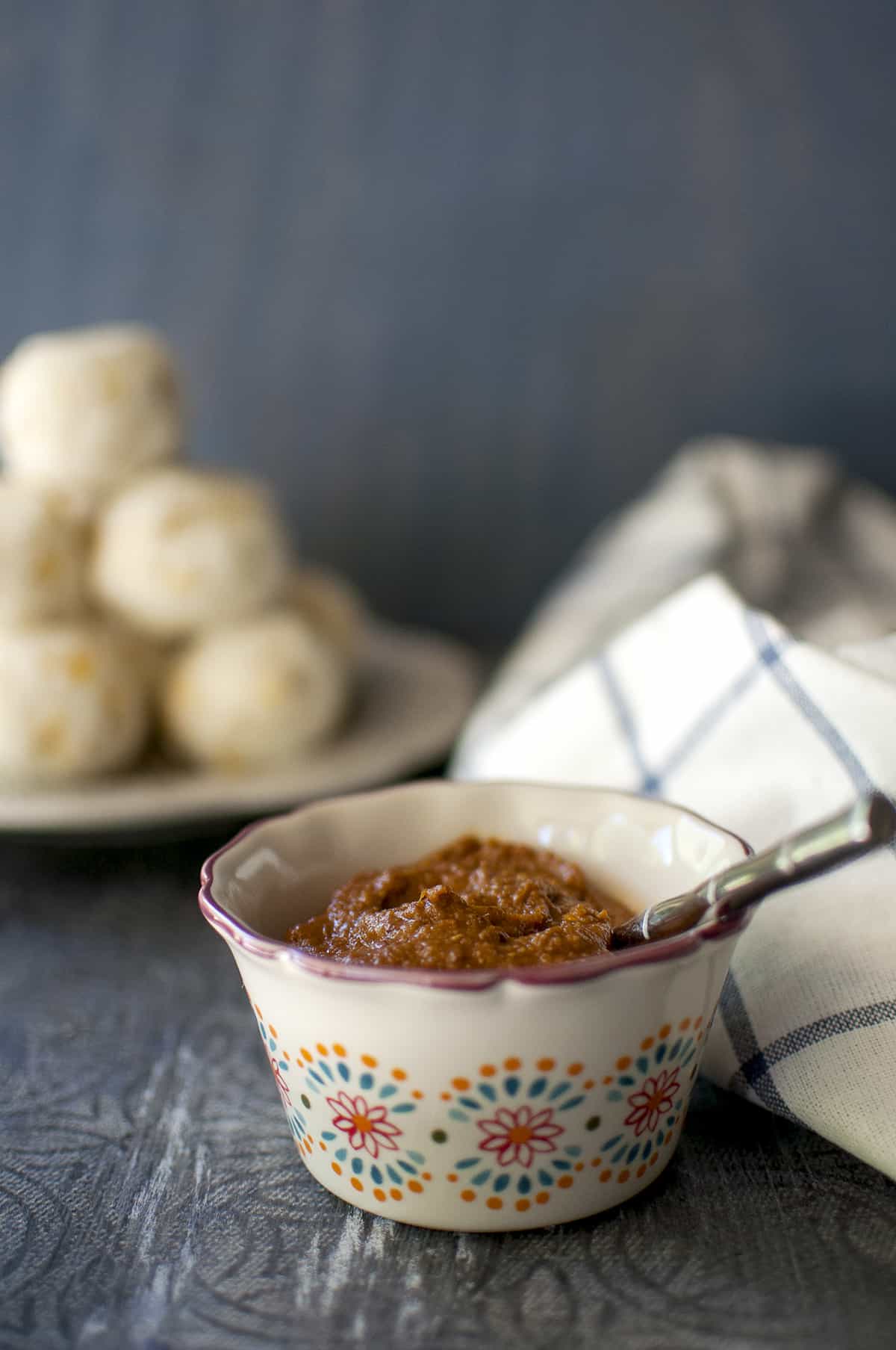 Cream bowl with allam chutney and undrallu in the background.