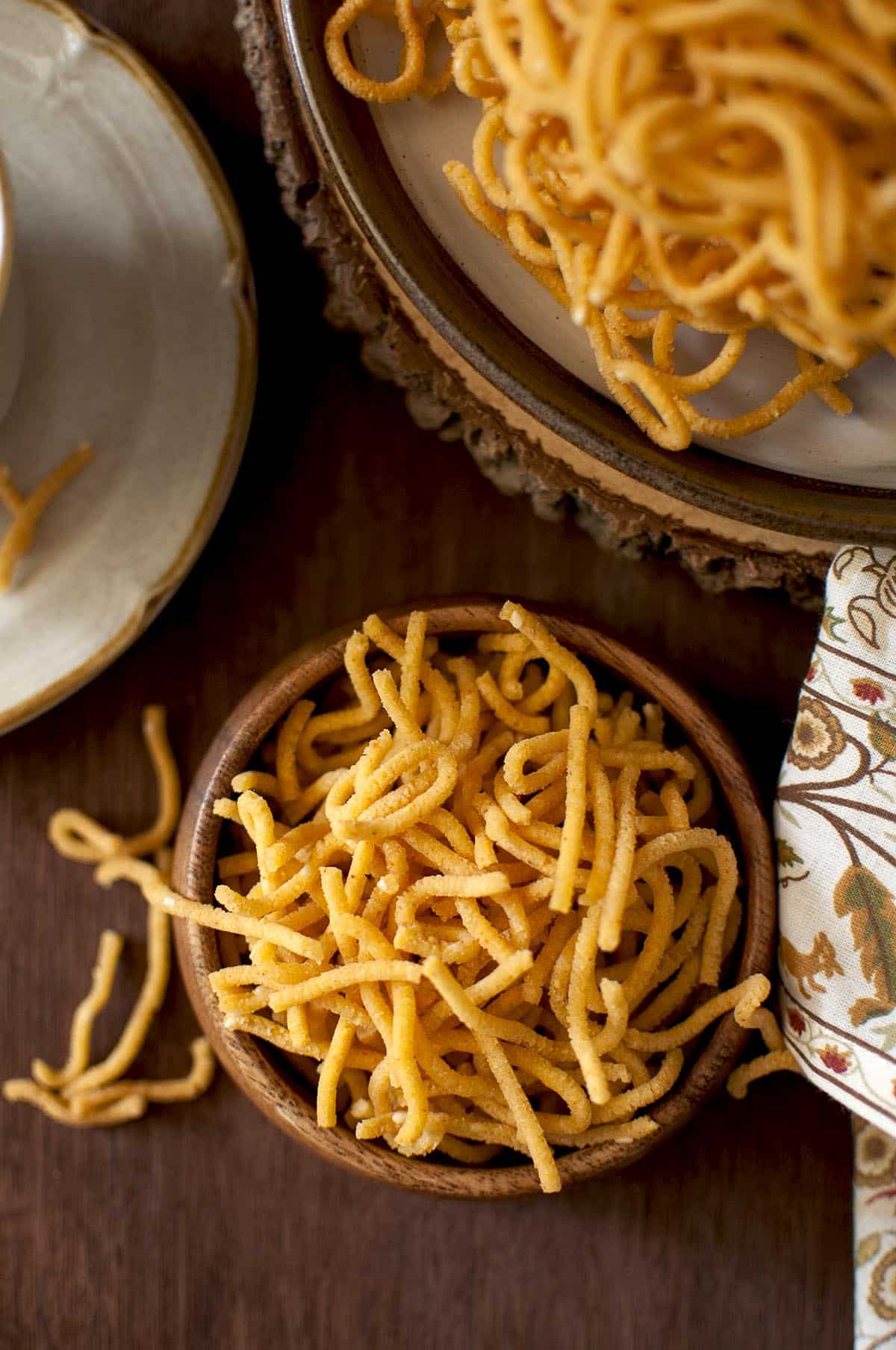 Top view of a wooden bowl filled with besan murukku