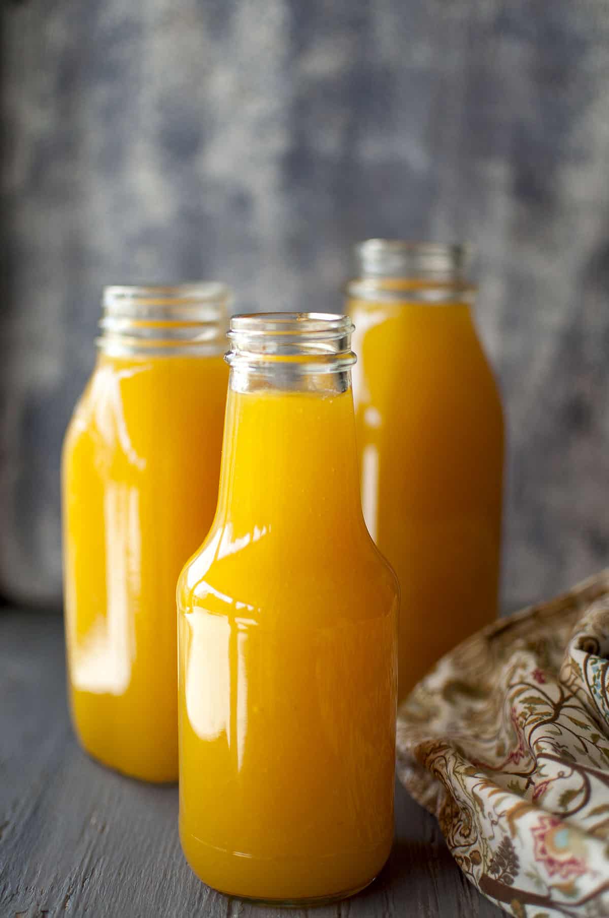 3 glass bottles with mango juice concentrate