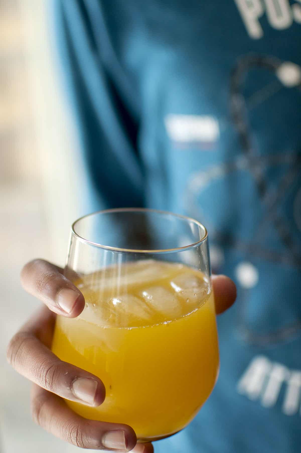 Hand holding a glass with drink