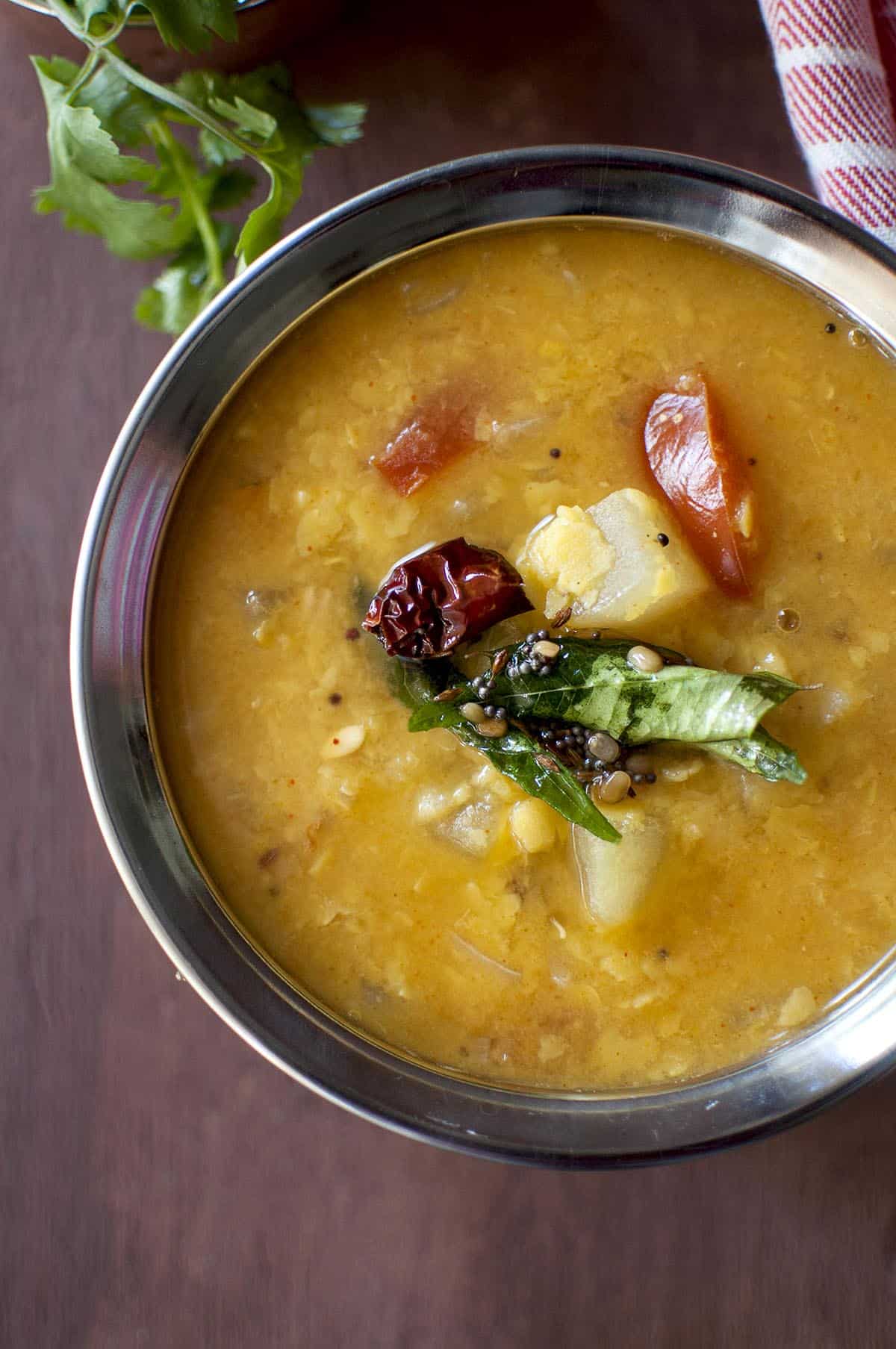 steel bowl with yellow cucumber dal