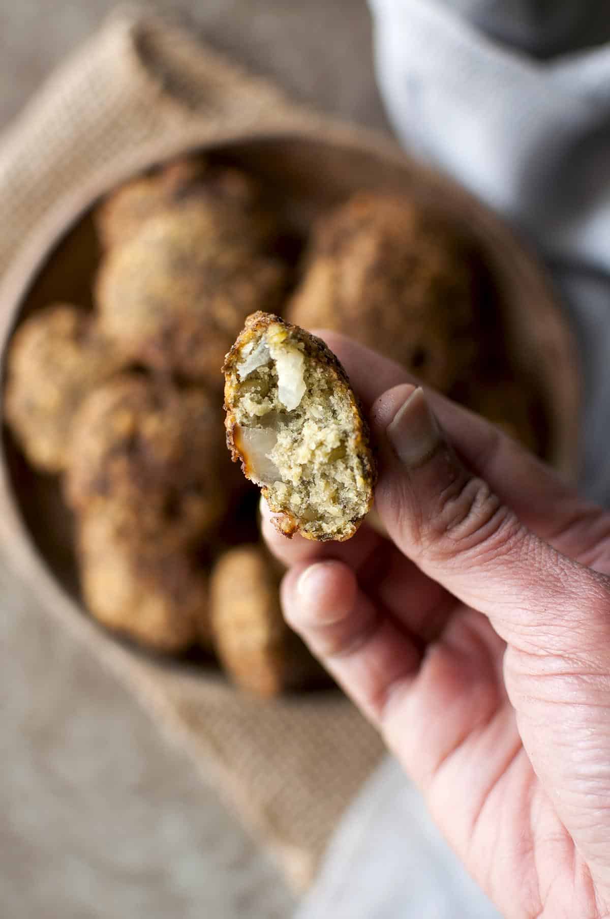 Hand holding half mung bean vada