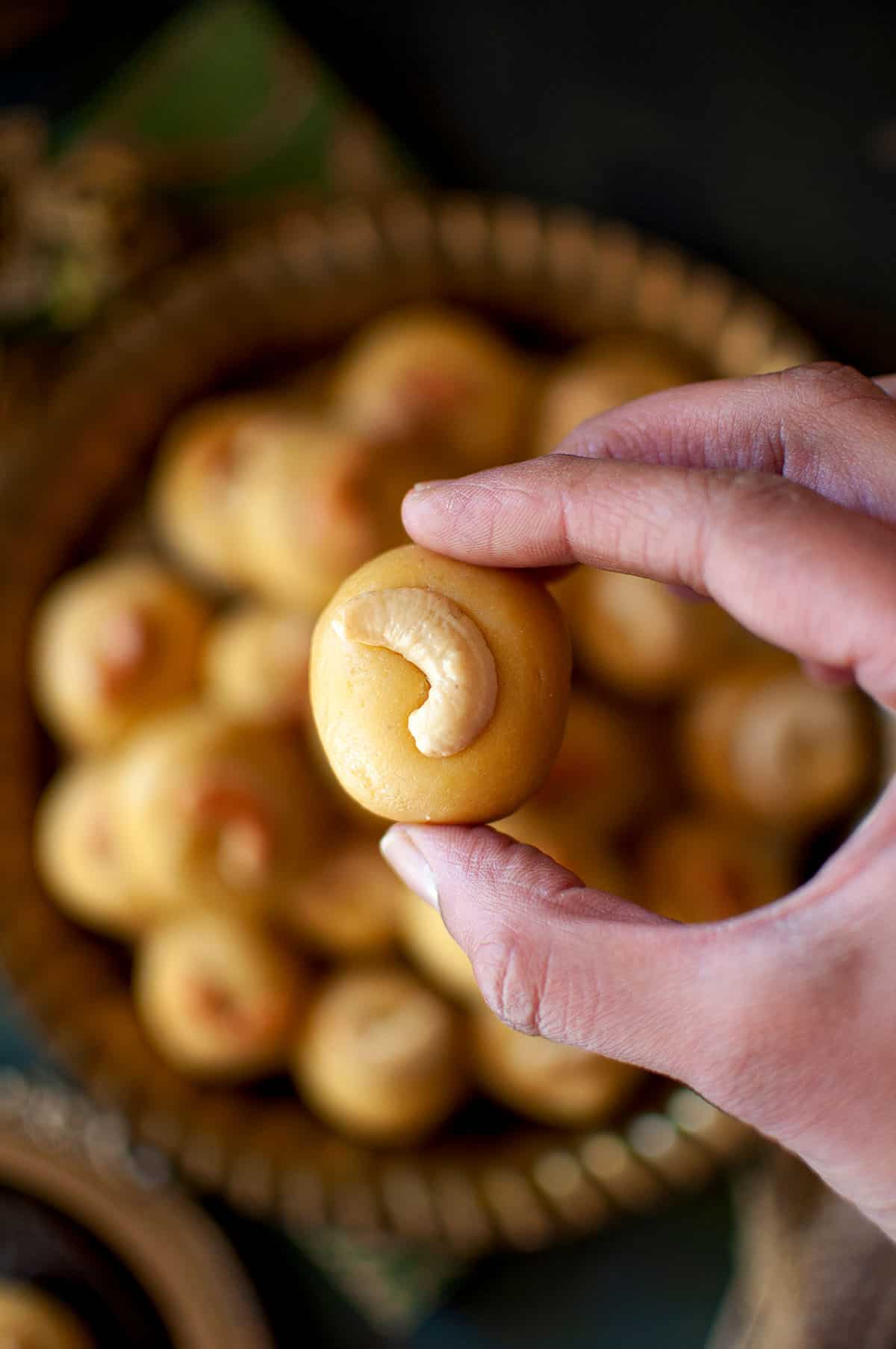 Hand holding a thokkudu laddu.