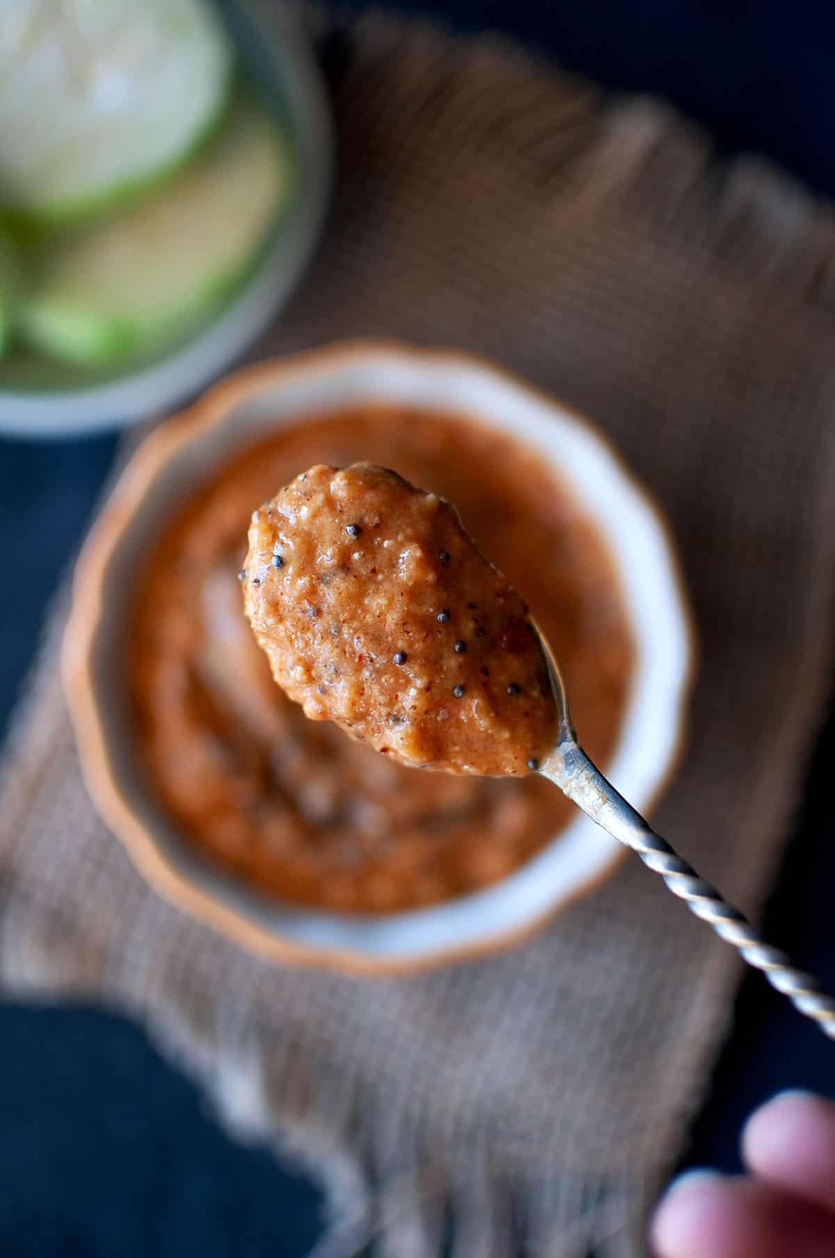 Spoon with nethi beerakaya chutney over a bowl.