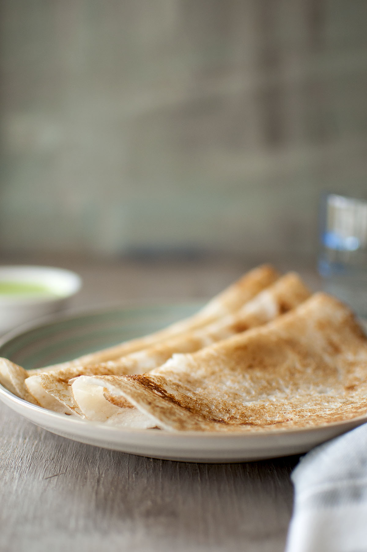 Blue plate with Indian crepes, poha dosa, with chutney