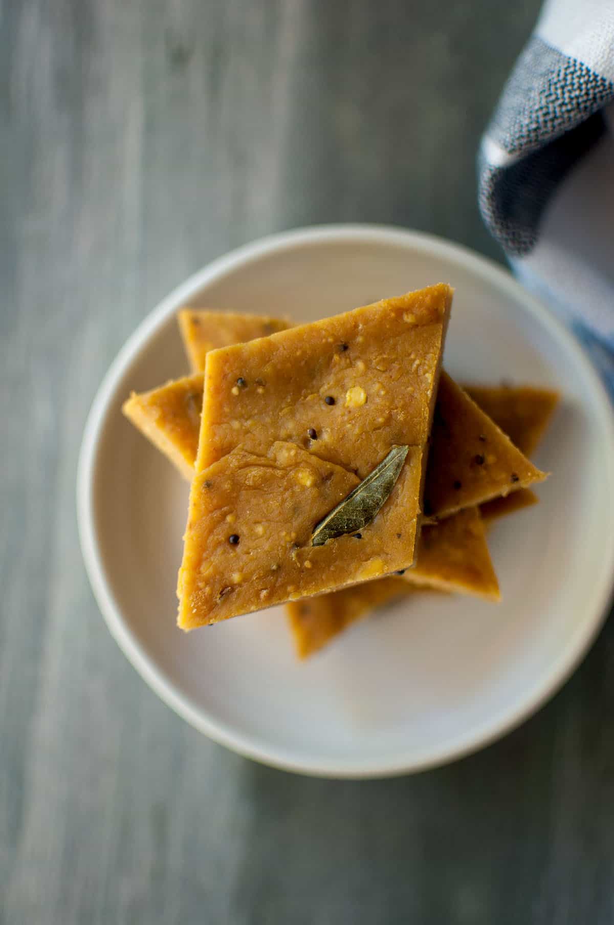 White plate with a stack of besan burfi.