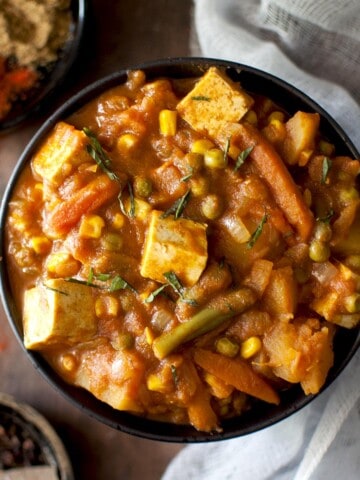 Black bowl with mixed vegetable tofu curry