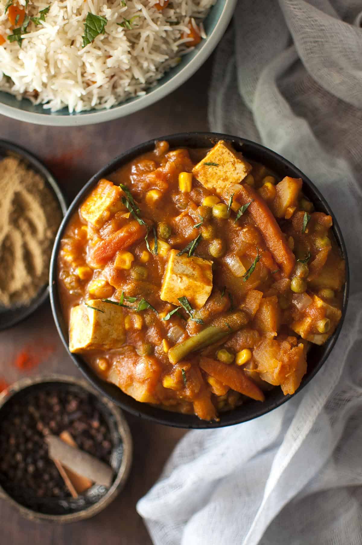 Top view of black bowl with vegetable vindaloo