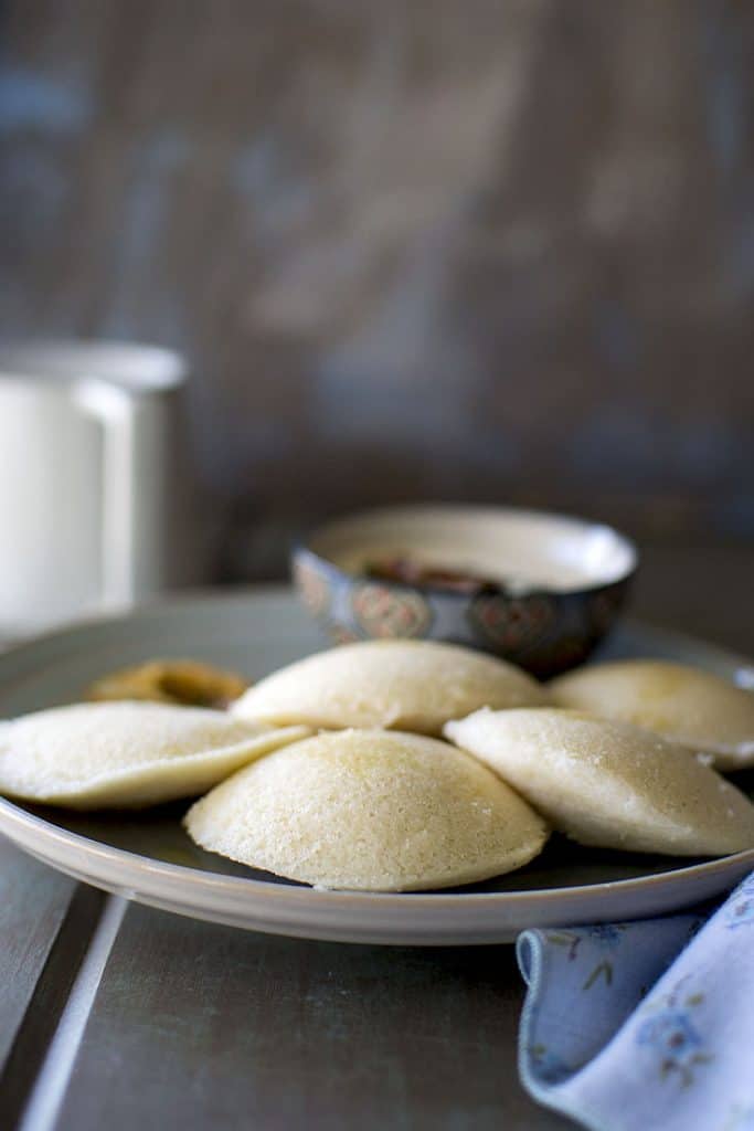 Grey plate with steamed idli and coconut chutney