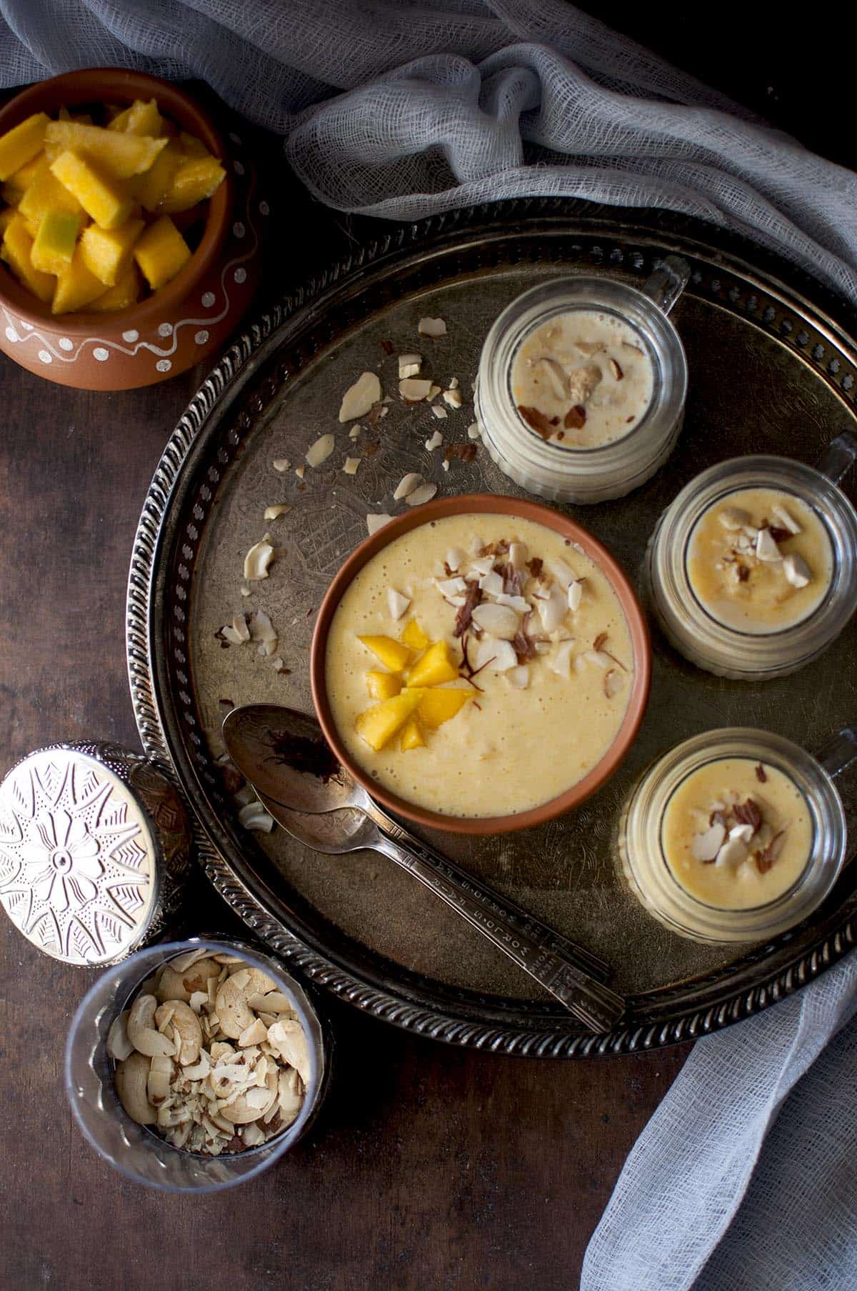 Large tray with terracotta bowl and glasses with mango pudding