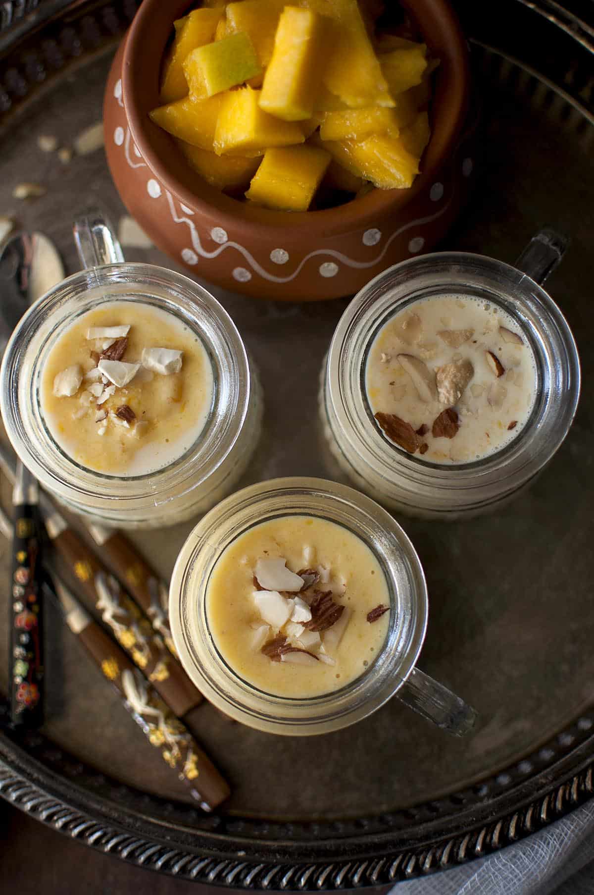 Tray with glasses with fruity pudding topped with chopped nuts