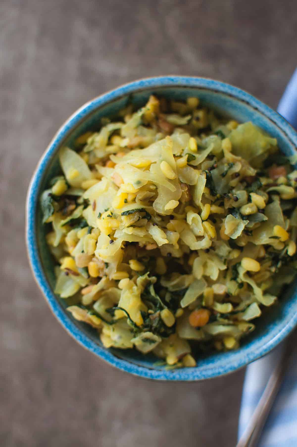 Blue bowl with spinach cabbage lentil curry.