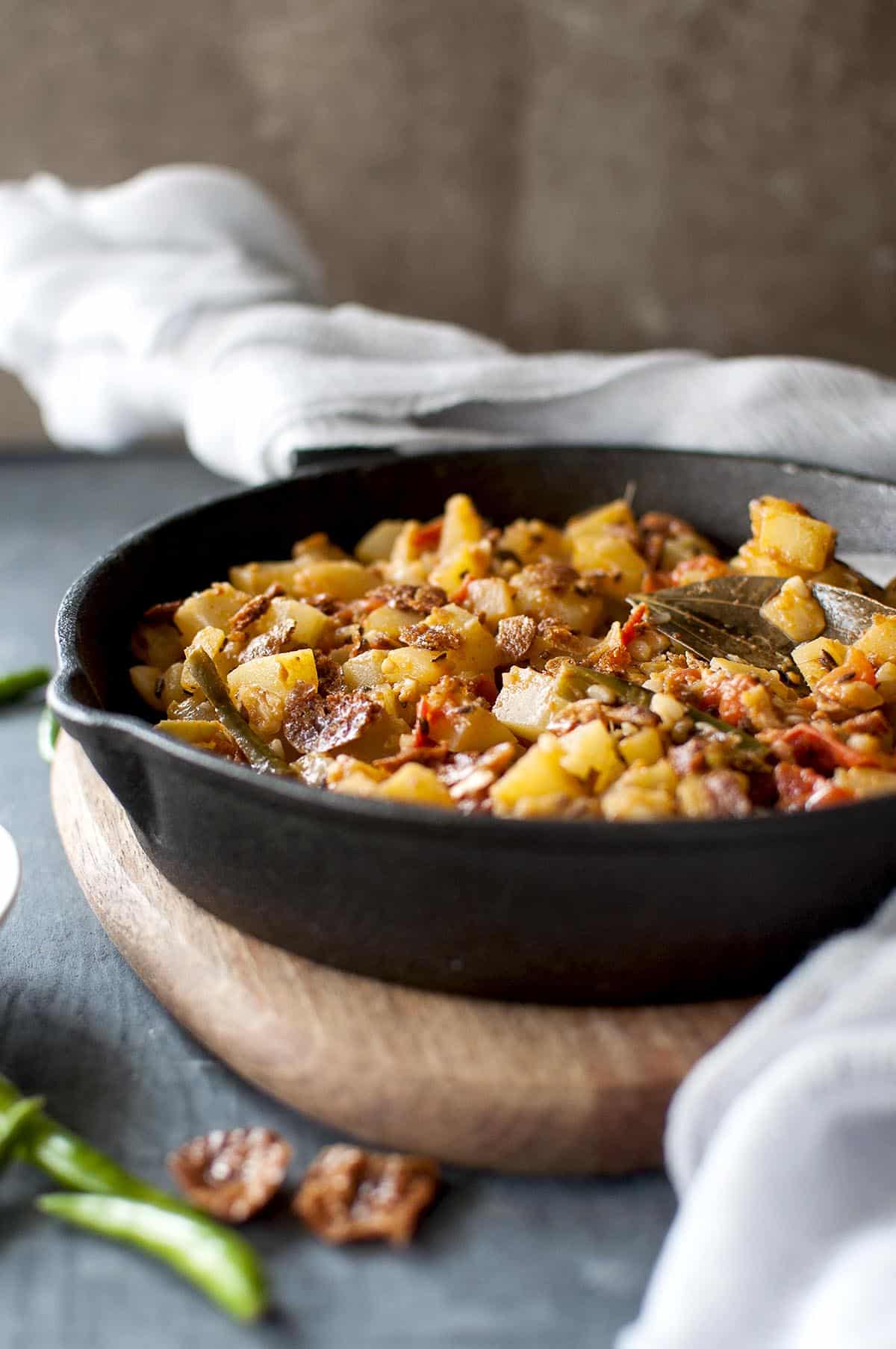 Cast iron pan with bottle gourd, tomato curry topped with vadi