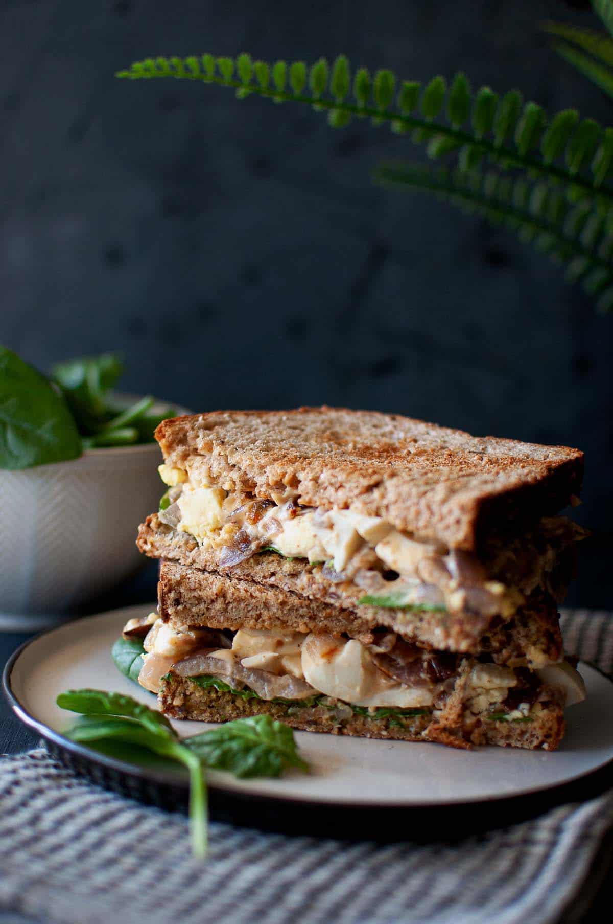 White plate with halved sandwich.