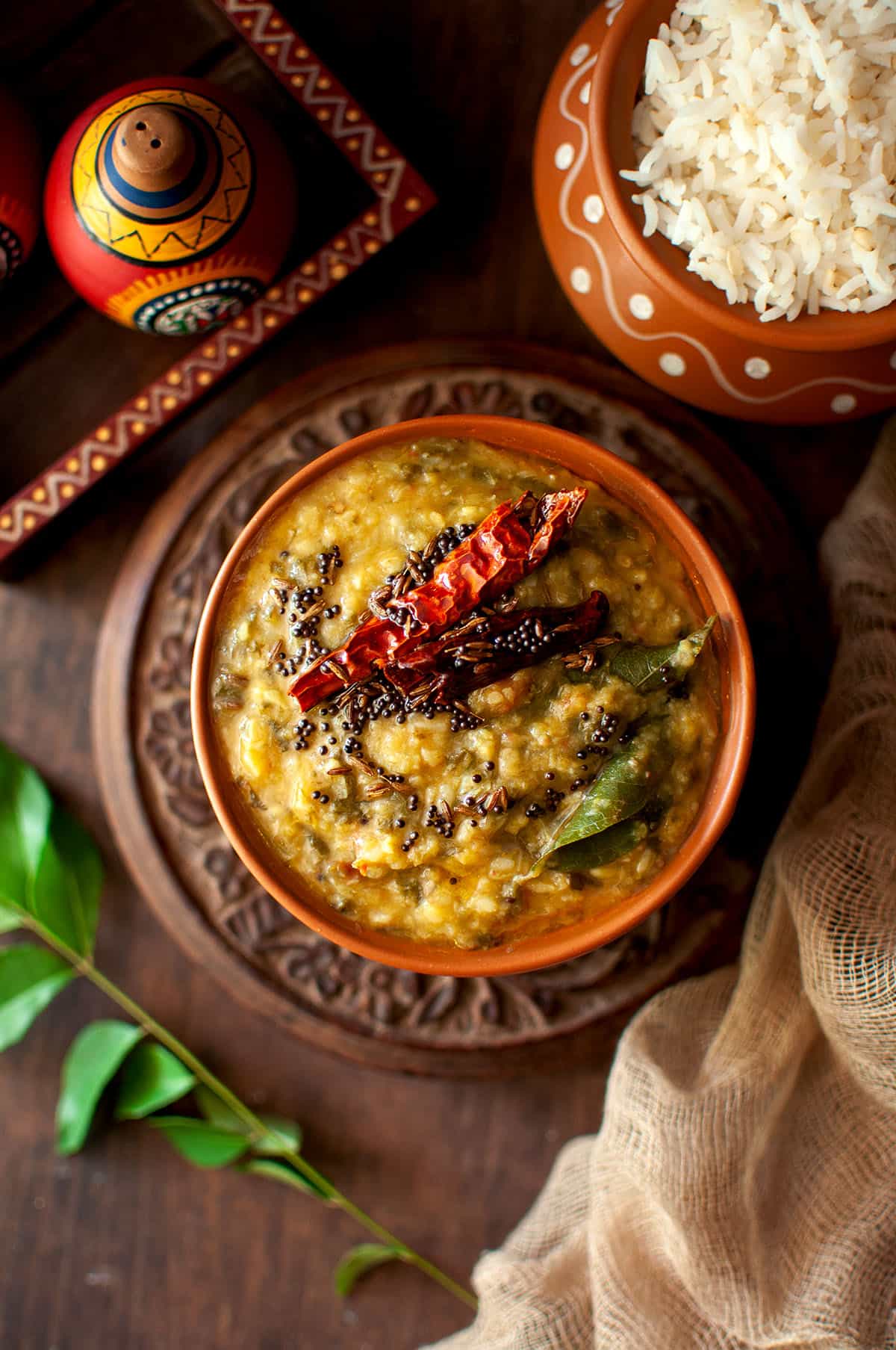 Terracotta bowl with chukka kura pappu topped with tadka.