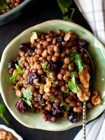 Green plate with brown lentil salad.