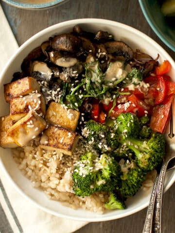 White bowl with brown rice and vegetavles.