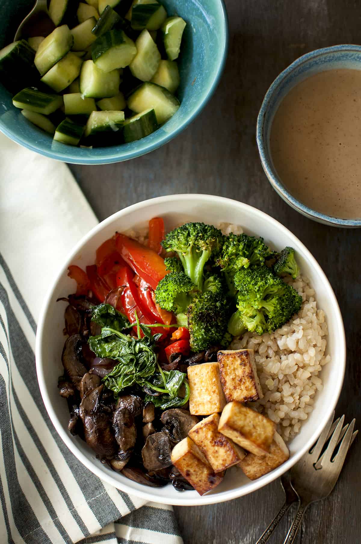 Brown rice veggie bowl topped with baked tofu.