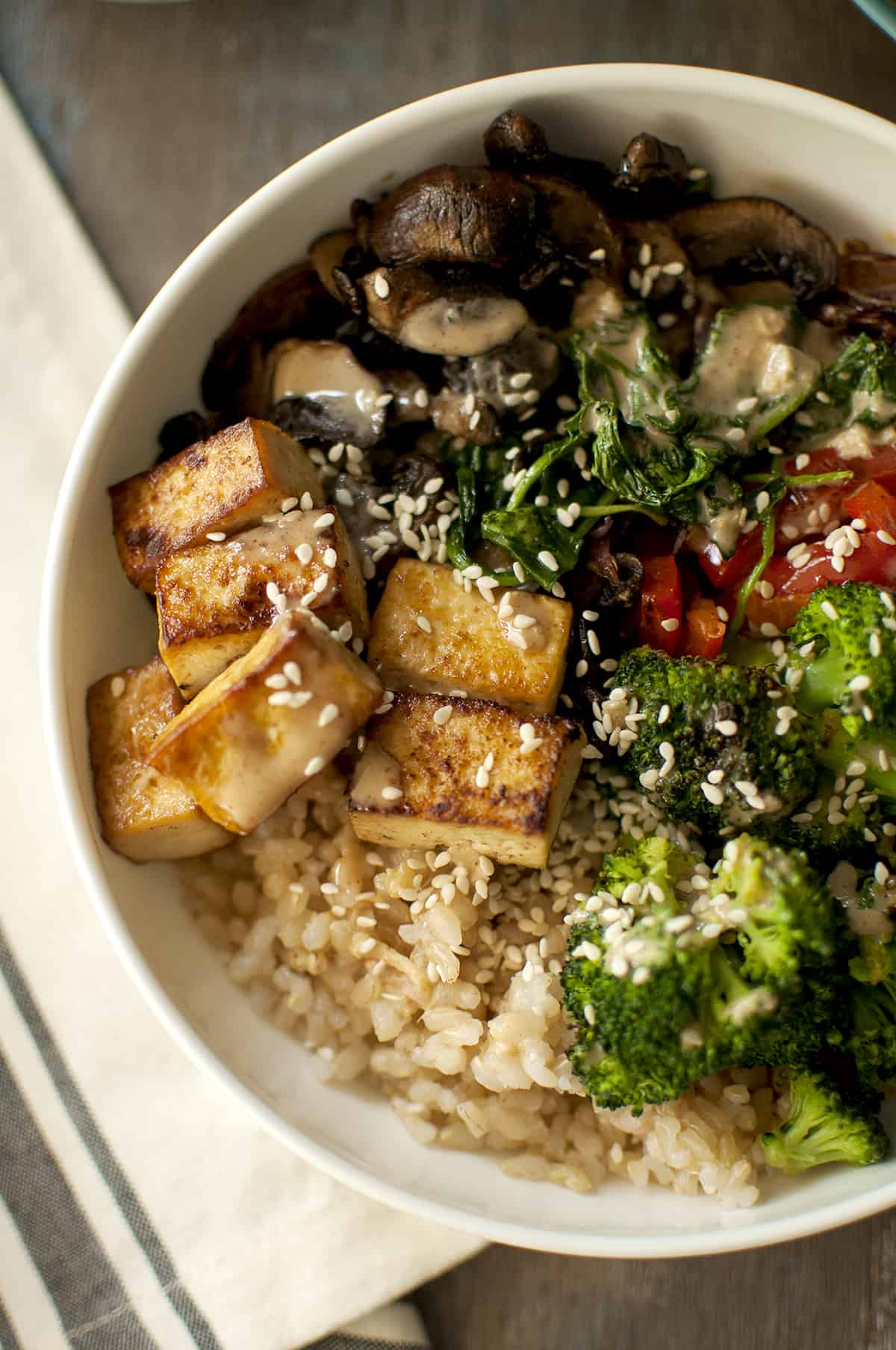 Brown rice veggie bowl topped with sesame seeds.