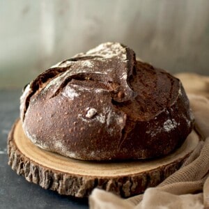 Wooden chopping board with a loaf of chocolate sourdough bread