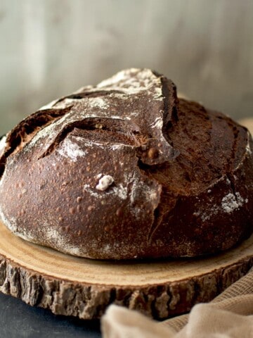 Wooden chopping board with a loaf of chocolate sourdough bread