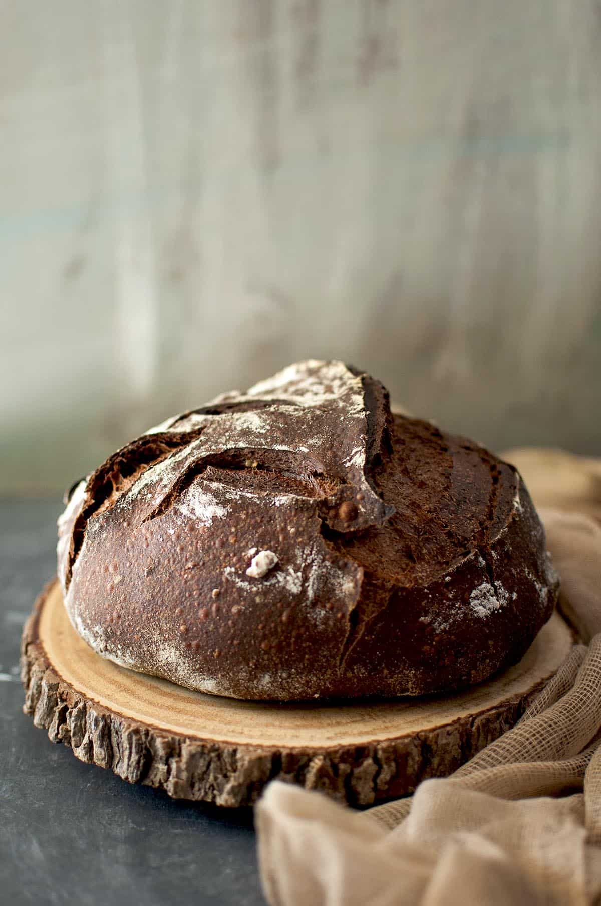 Wooden chopping board with a loaf of chocolate sourdough bread