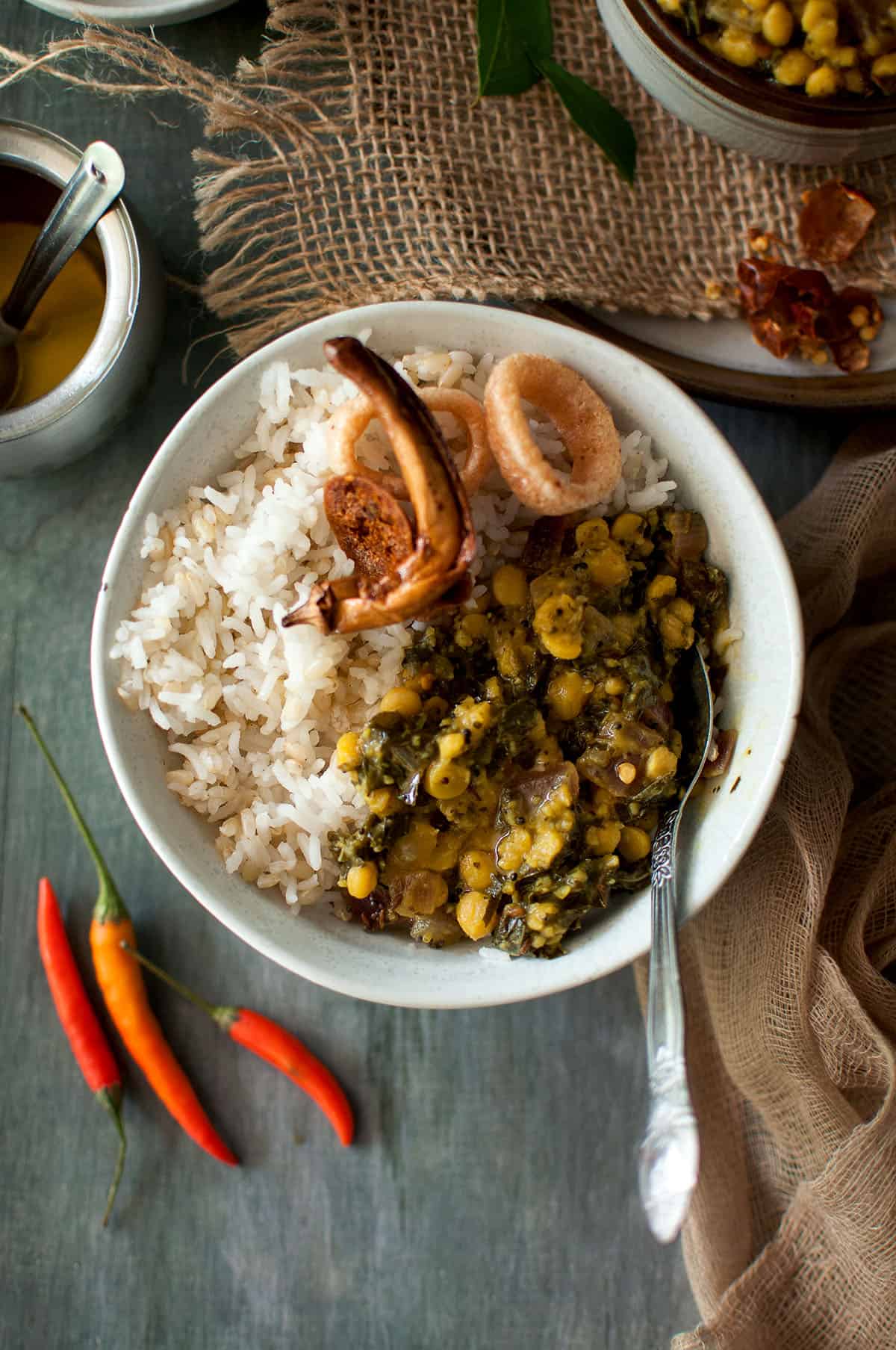 White bowl with dal, rice and vadiyalu.