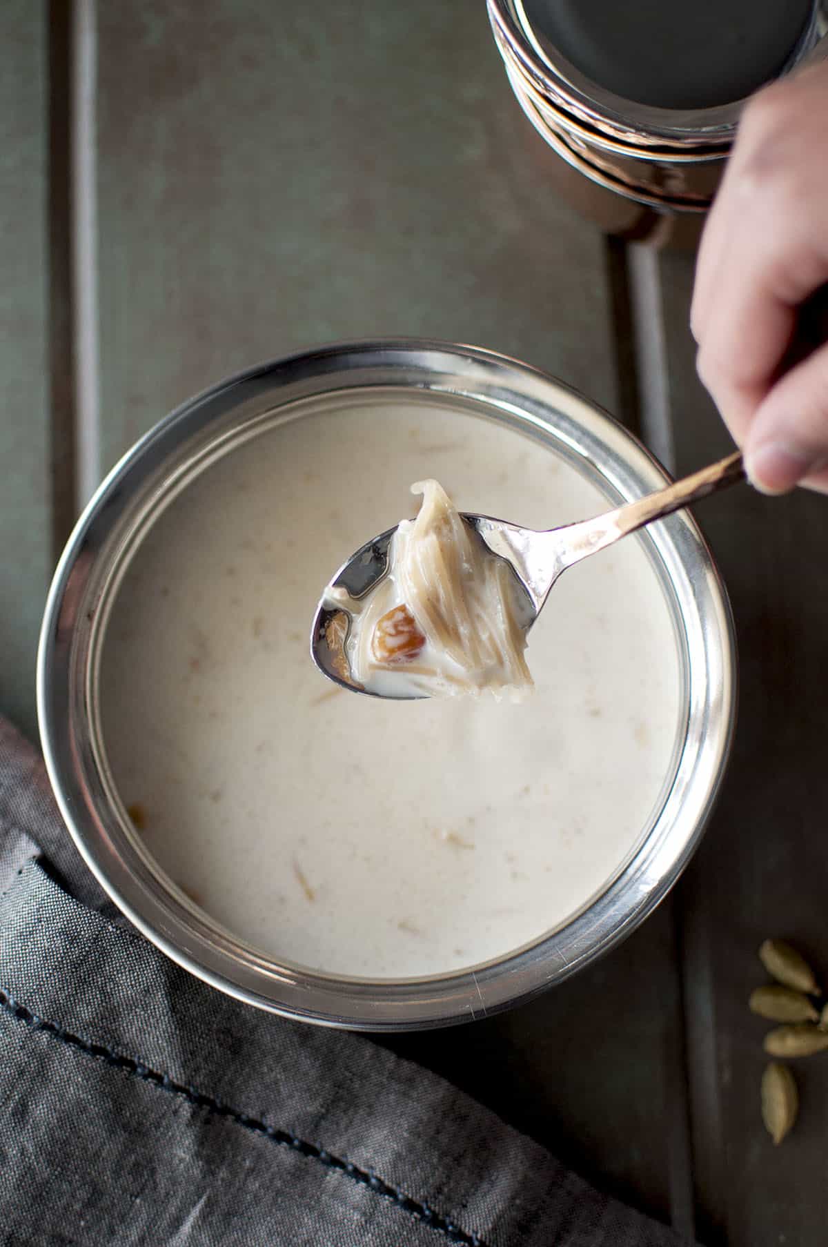 Hand holding a spoon with semya payasam