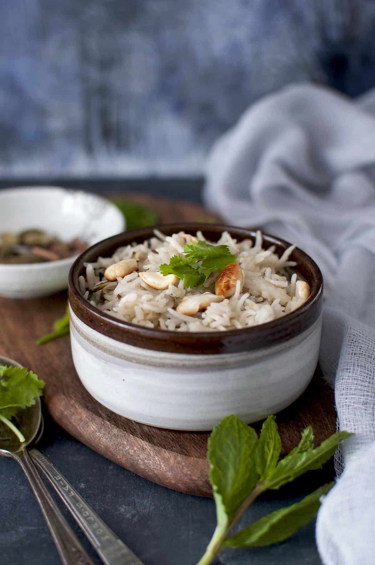 Brown bowl with Hyderabadi bagara rice topped with cilantro