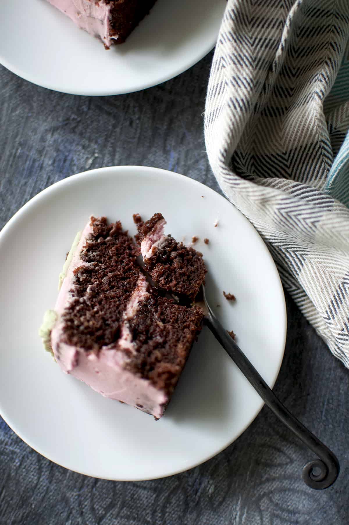 White plate with a slice of chocolate cake and a fork