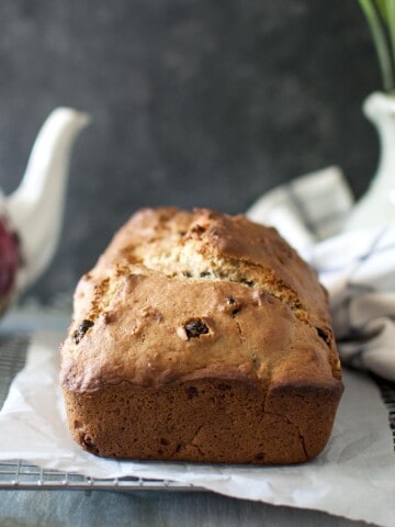 A loaf of banana bread on parchment lined wire rack