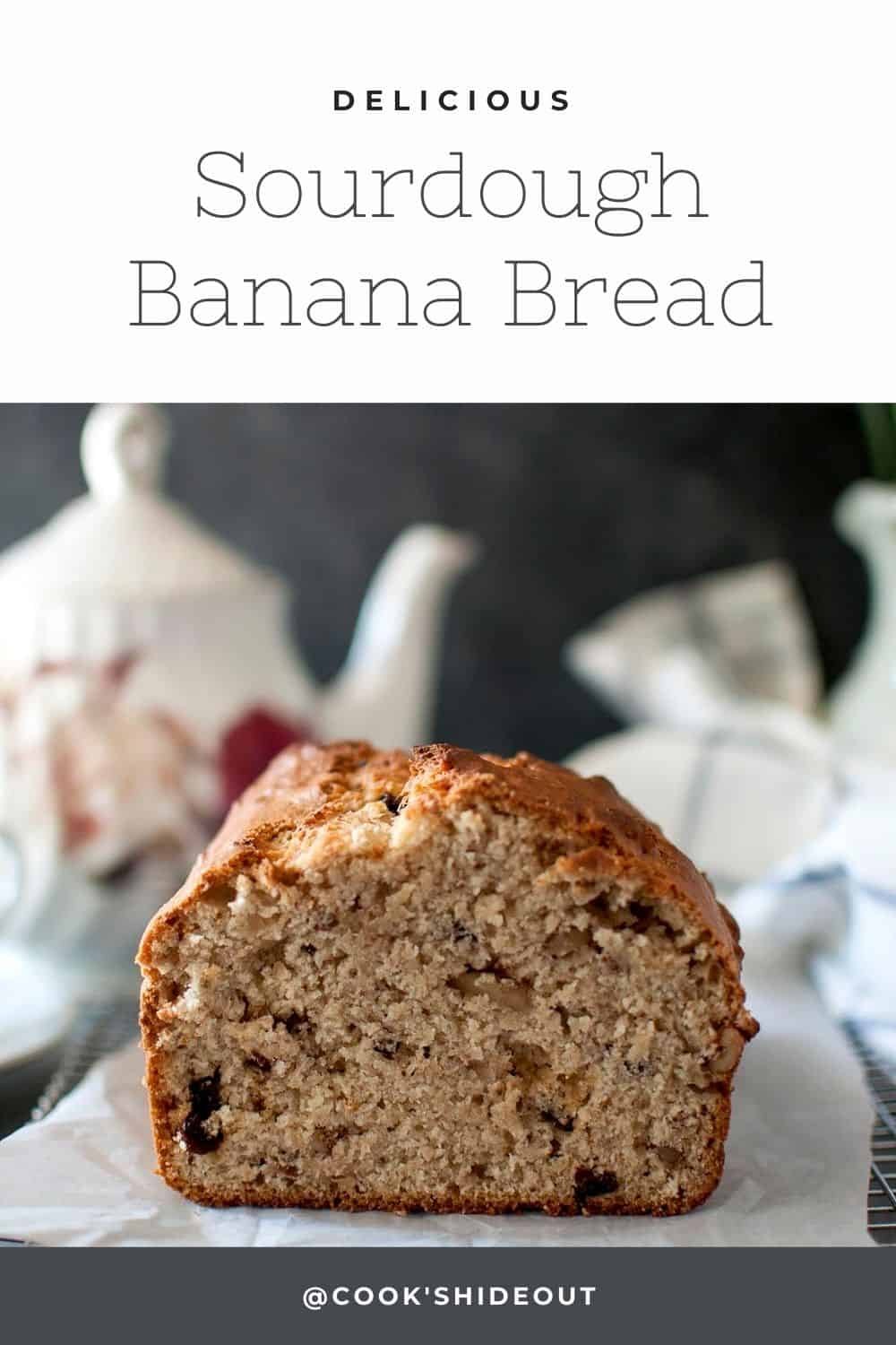 Loaf of banana bread placed on parchment lined wire rack