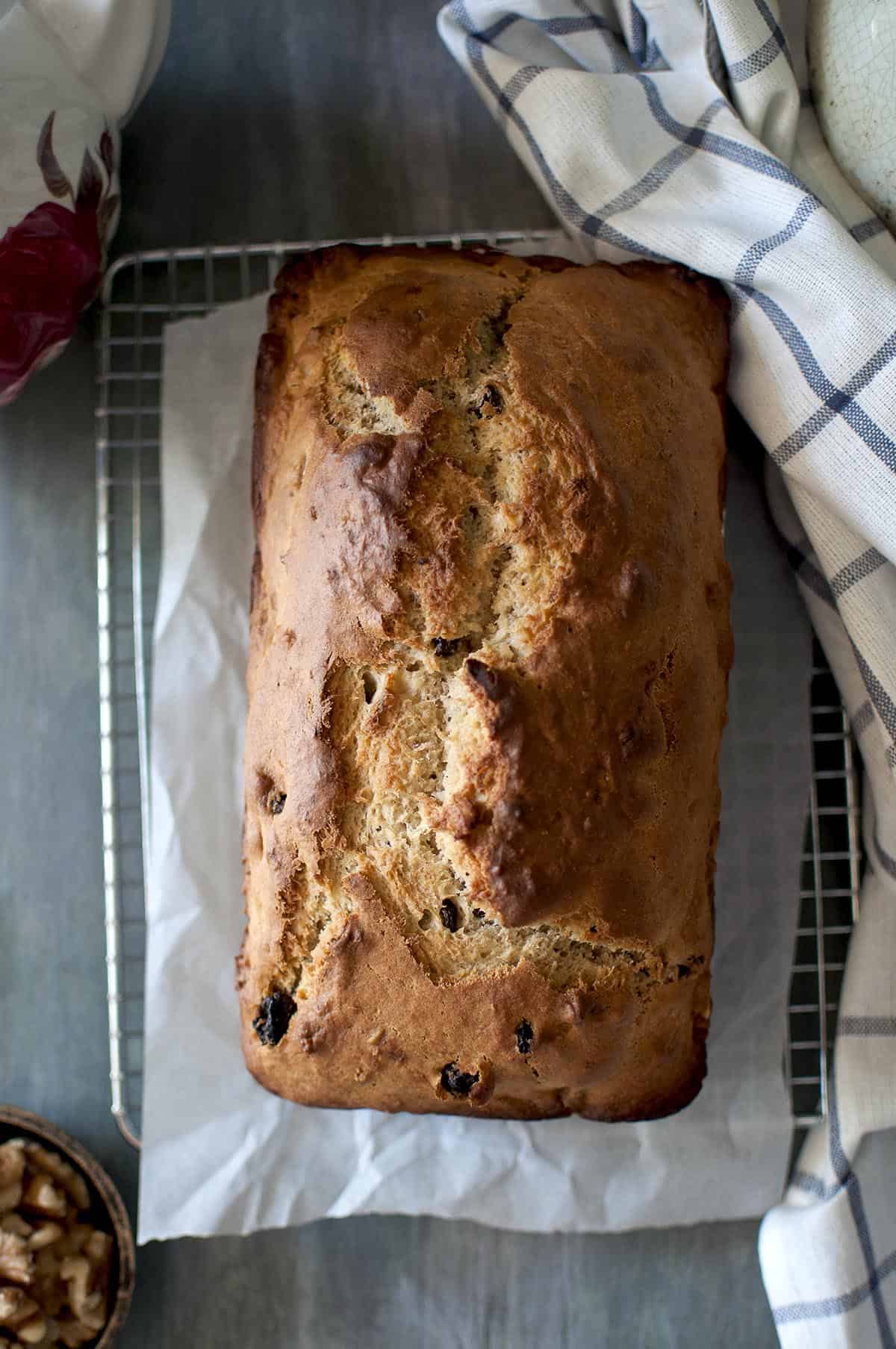 Top view of a loaf of banana bread on a parchment lined wire rack