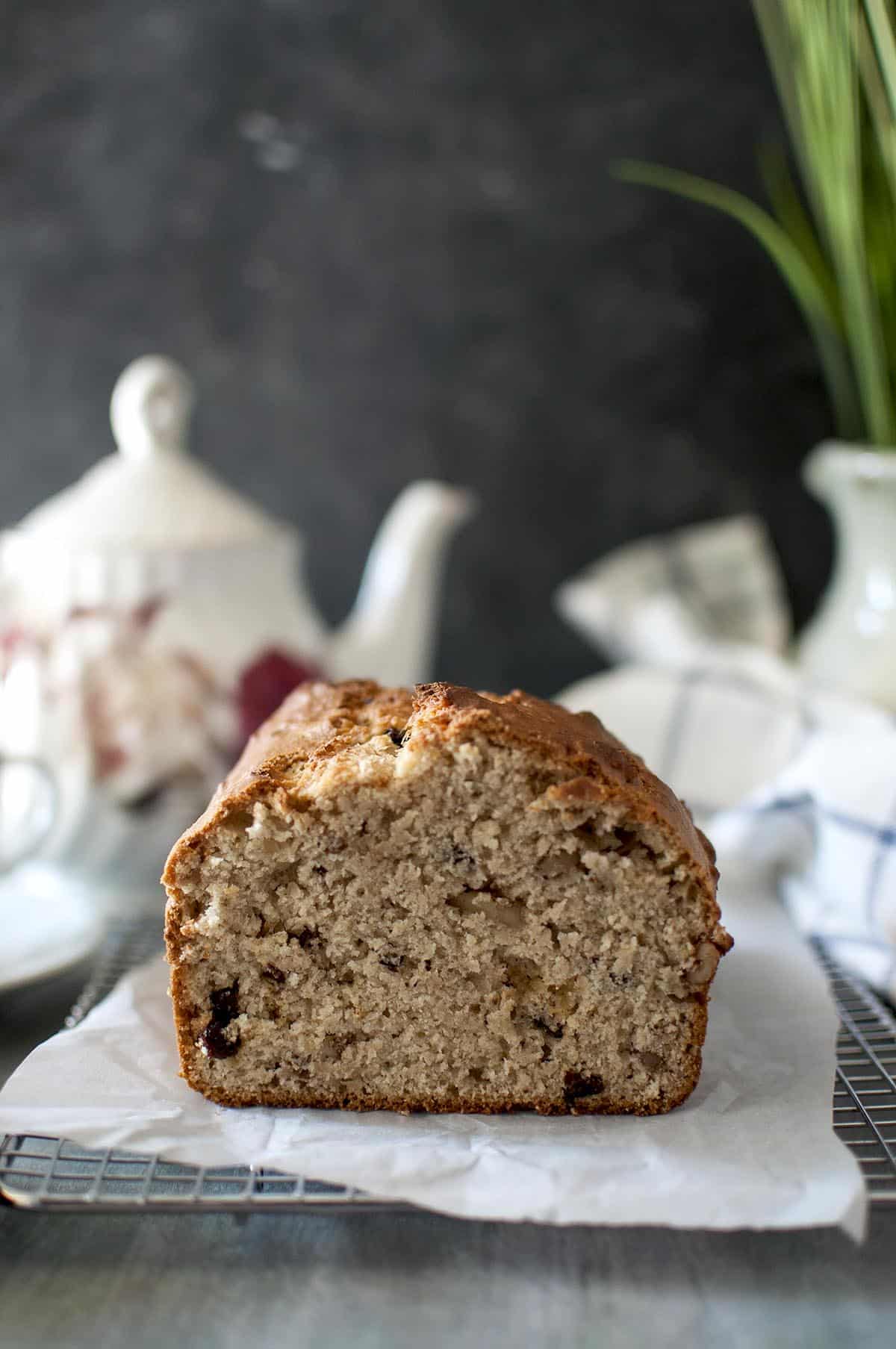 Loaf of banana bread placed on parchment lined wire rack