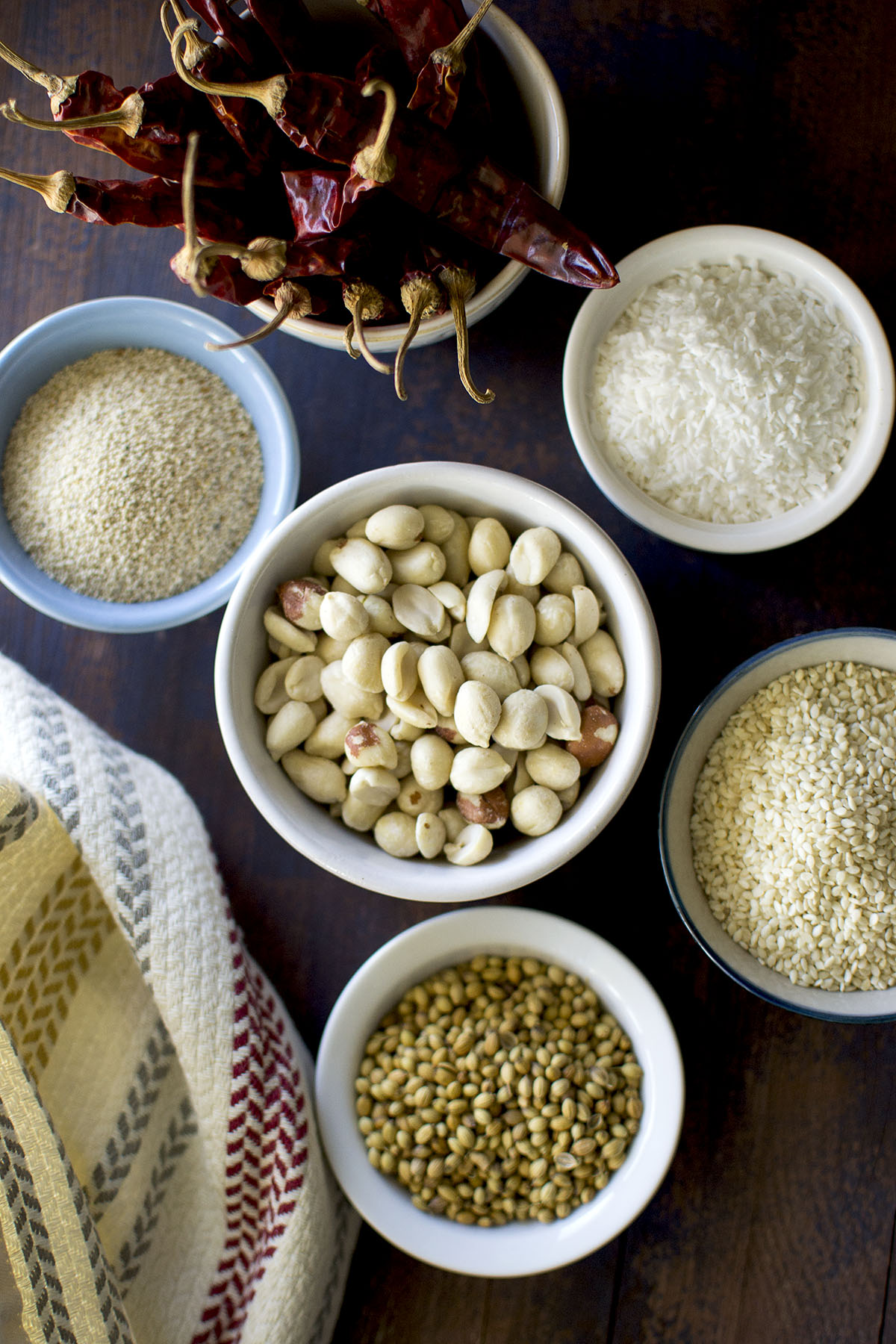 Bowls with Peanuts, sesame seeds, poppy seeds, coriander, grated coconut and dried red chilies