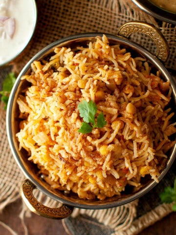 Brass bowl with Qabooli biryani.