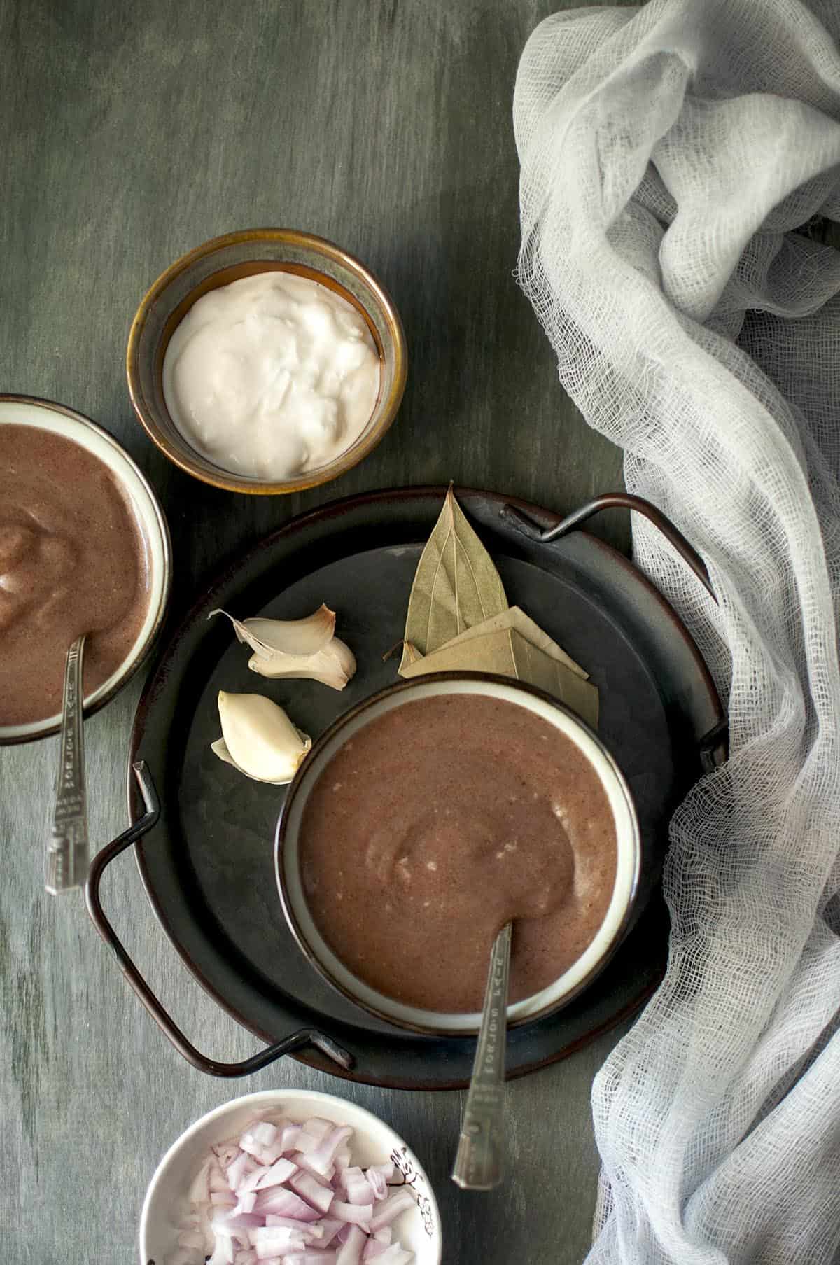 Black tray with a grey bowl of ragi porridge