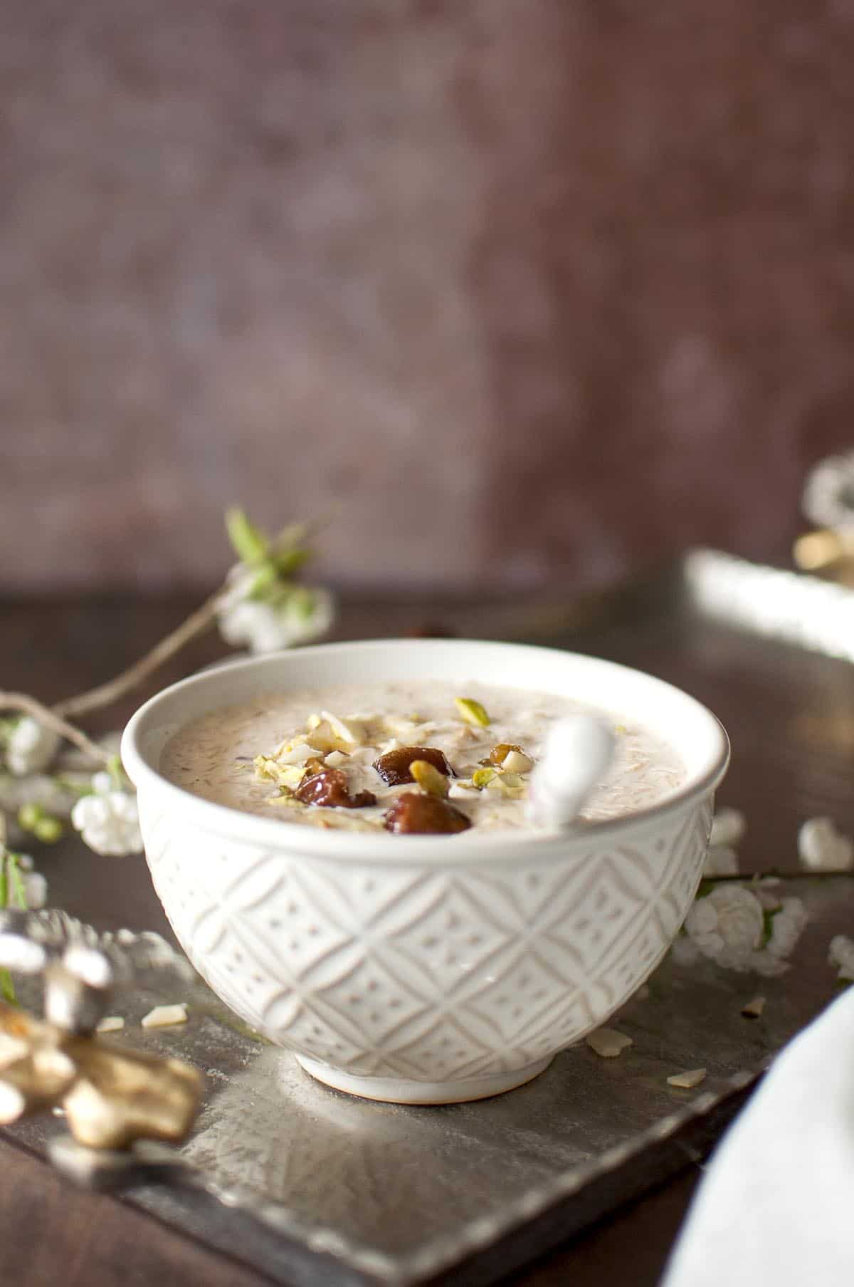 White bowl with sheer khurma with a spoon inside