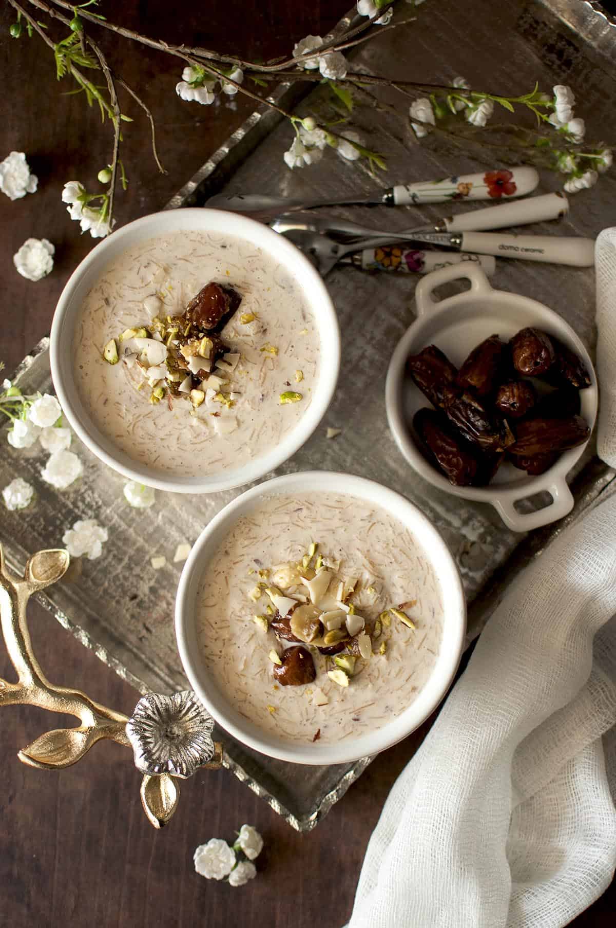 Top view of 2 bowls of sheer khurma on a silver tray