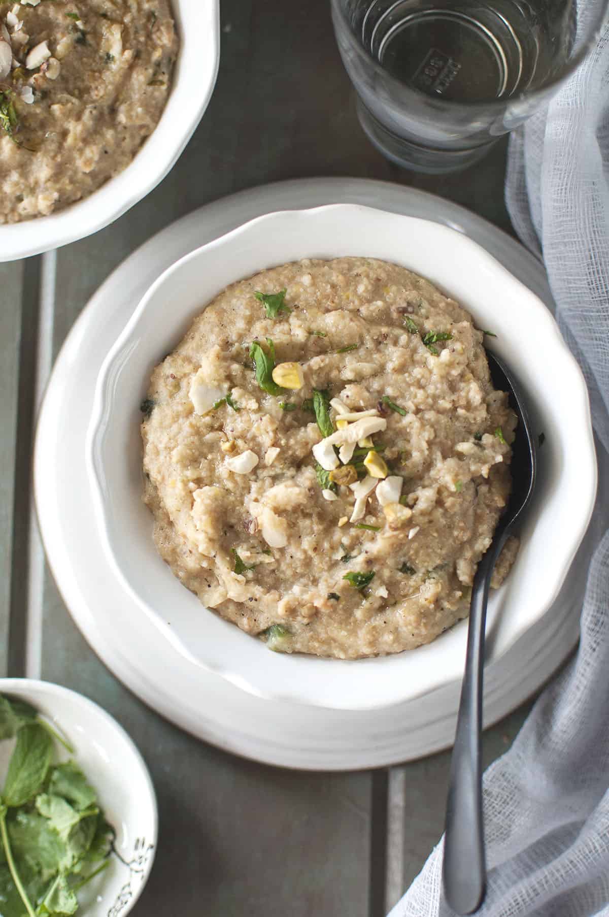 White bowl with Veg Haleem topped with chopped nuts