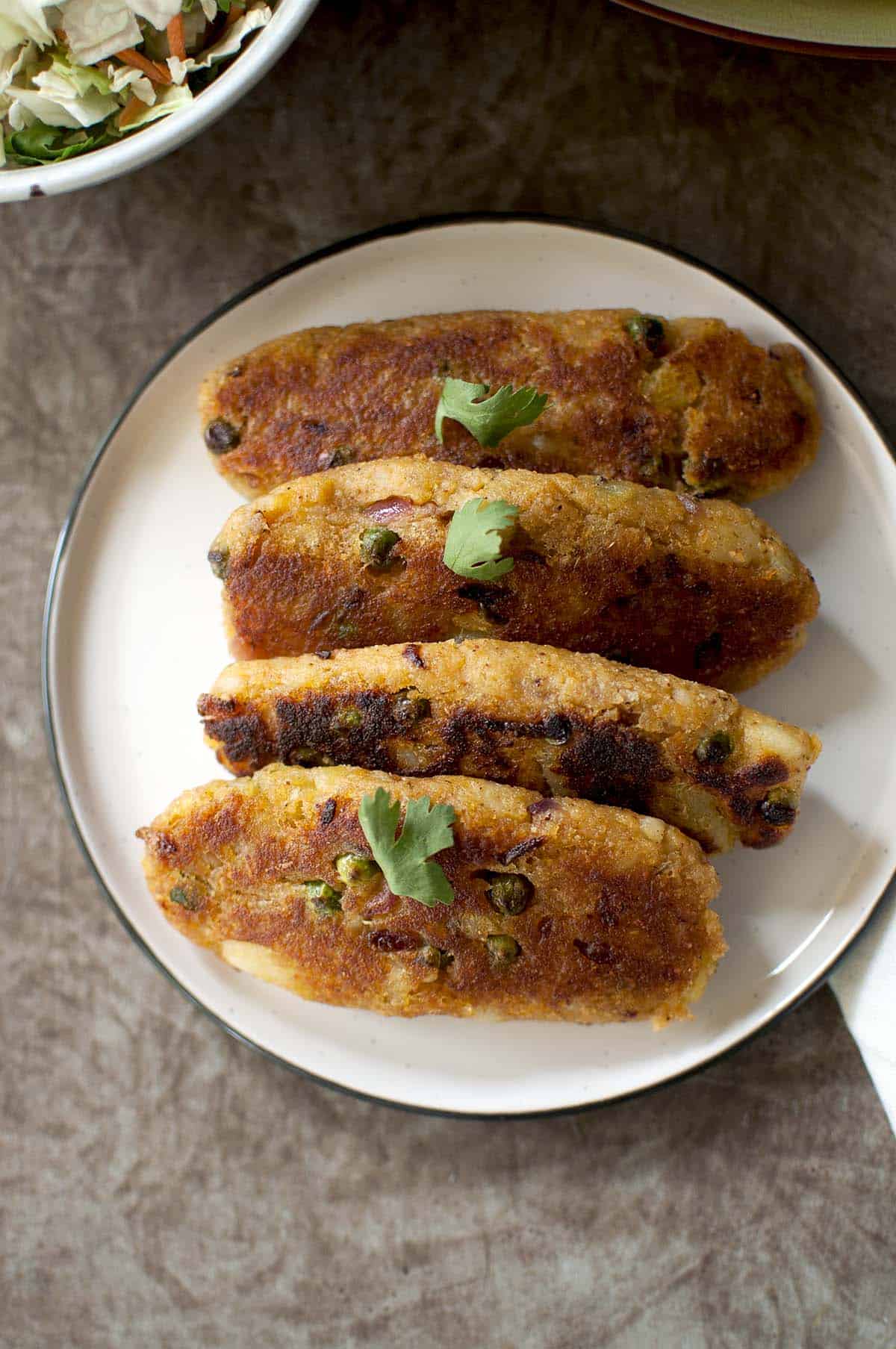 White plate with oblong shaped potato patties