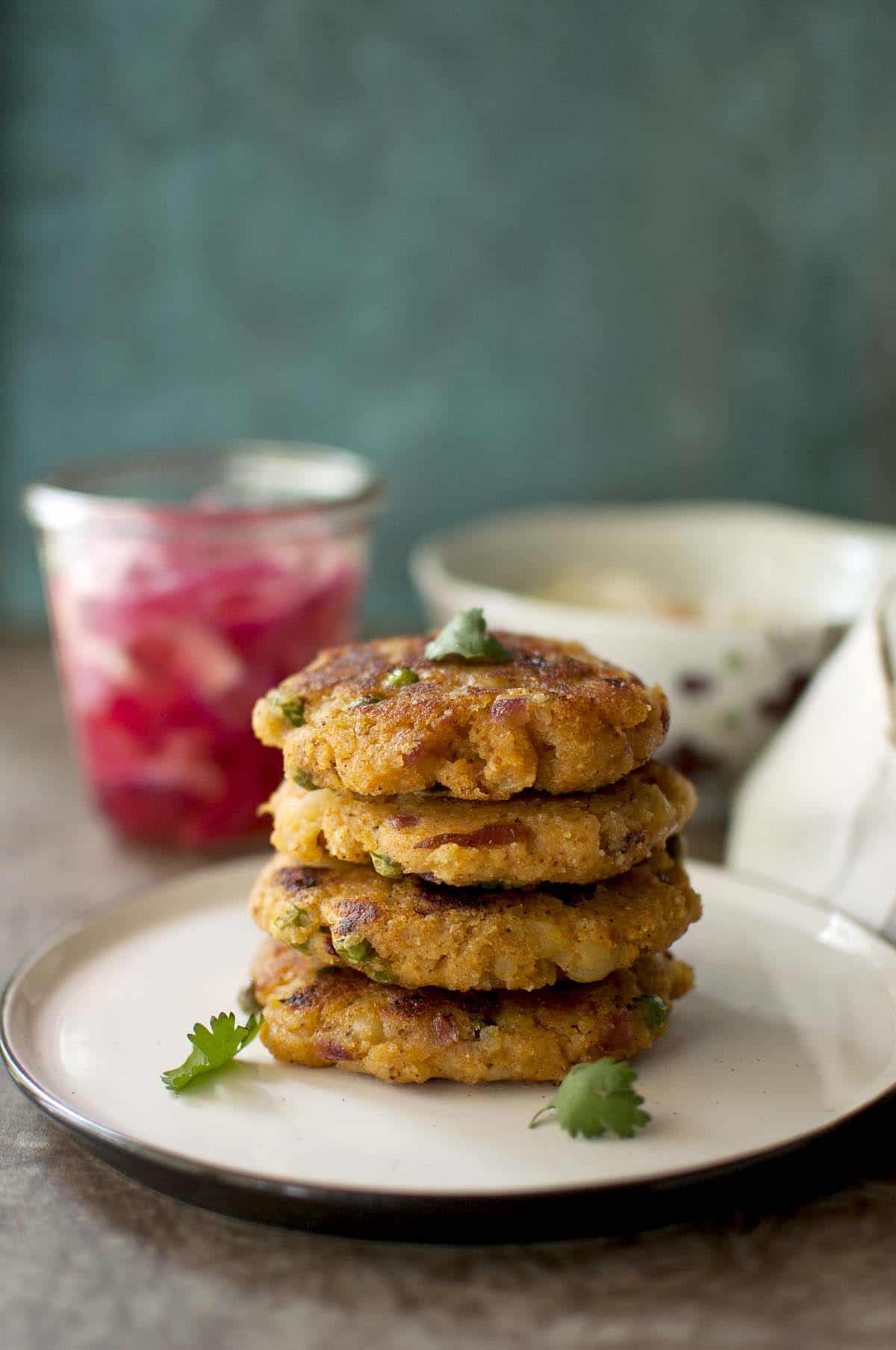 White plate with a stack of round aloo patty