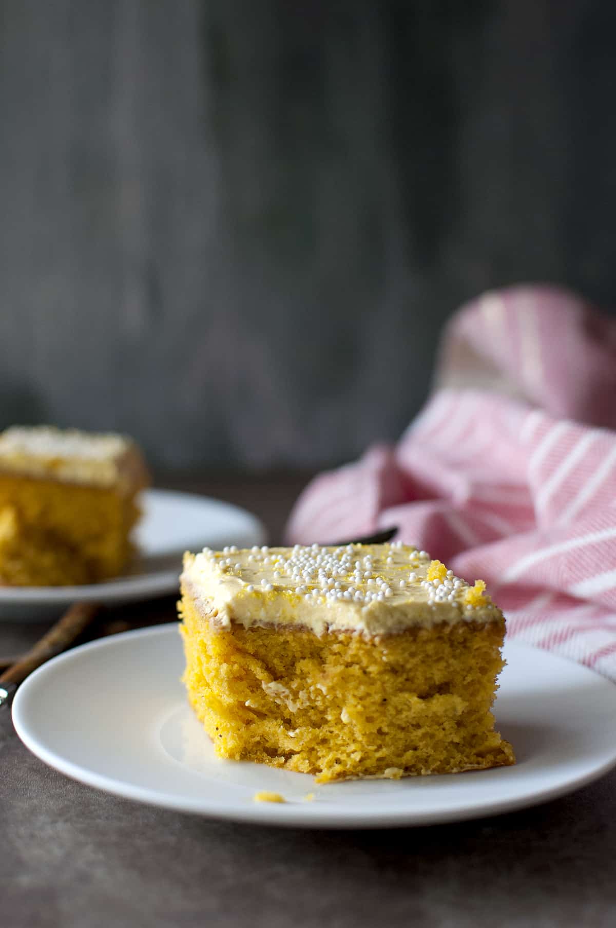 White plate with a slice of eggless mango cake