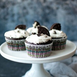 White cake stand with chocolate oreo cupcakes.