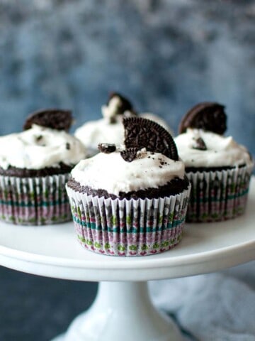 White cake stand with chocolate oreo cupcakes.