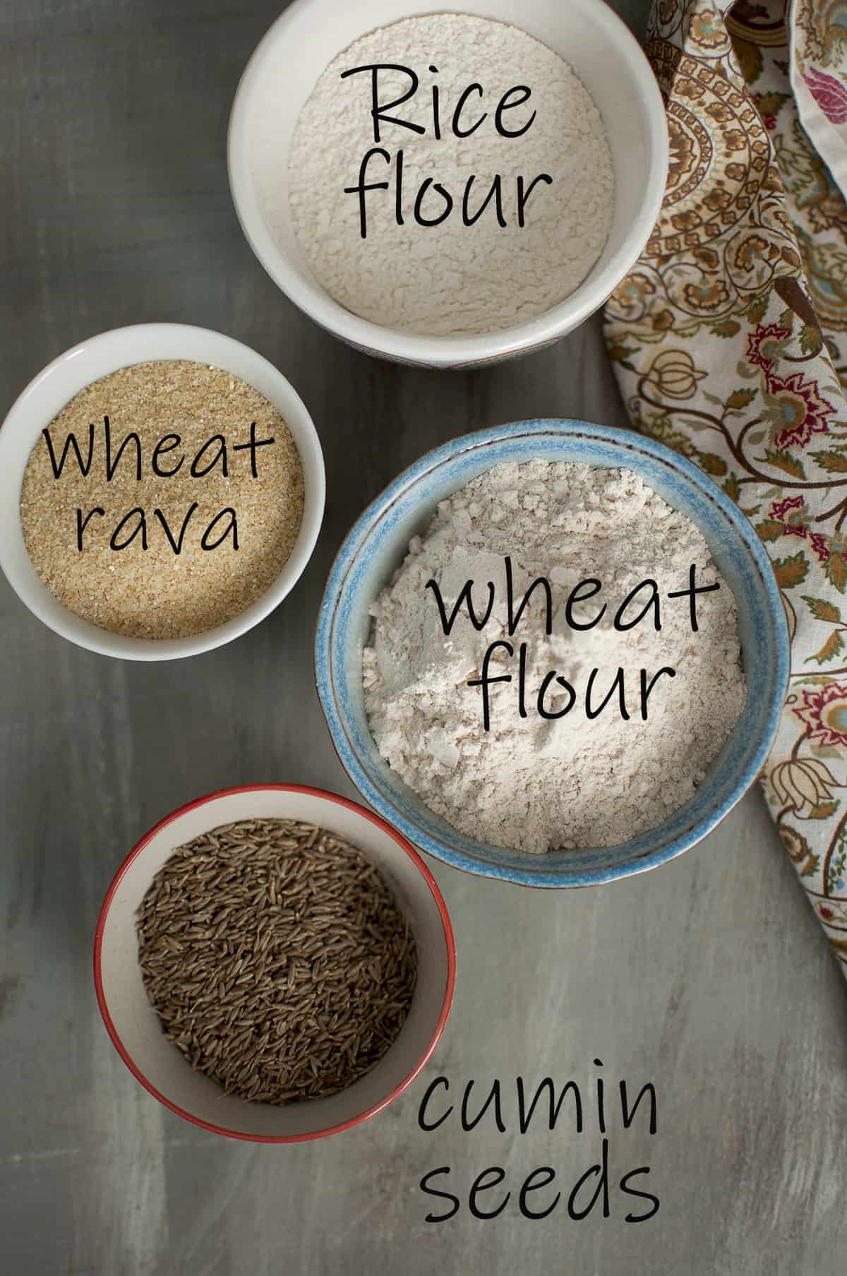 Bowls with Ingredients for the recipe - rice flour, wheat rava, wheat flour, cumin seeds