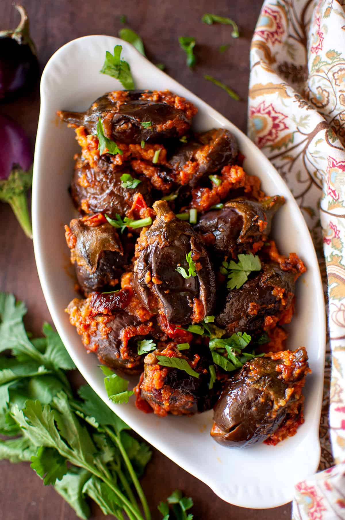 White oval bowl with stuffed brinjal fry.