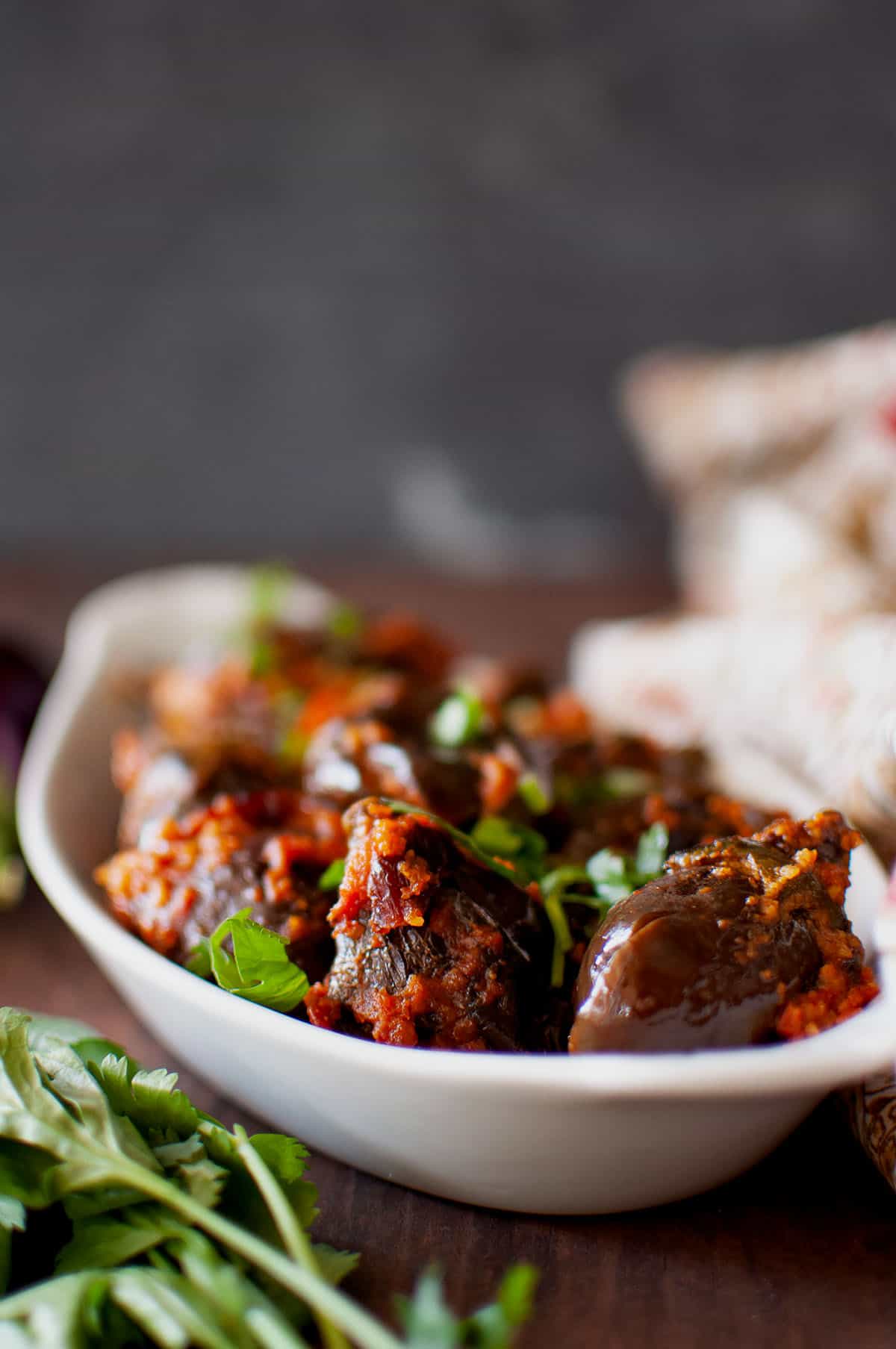 White bowl with stuffed brinjal fry.