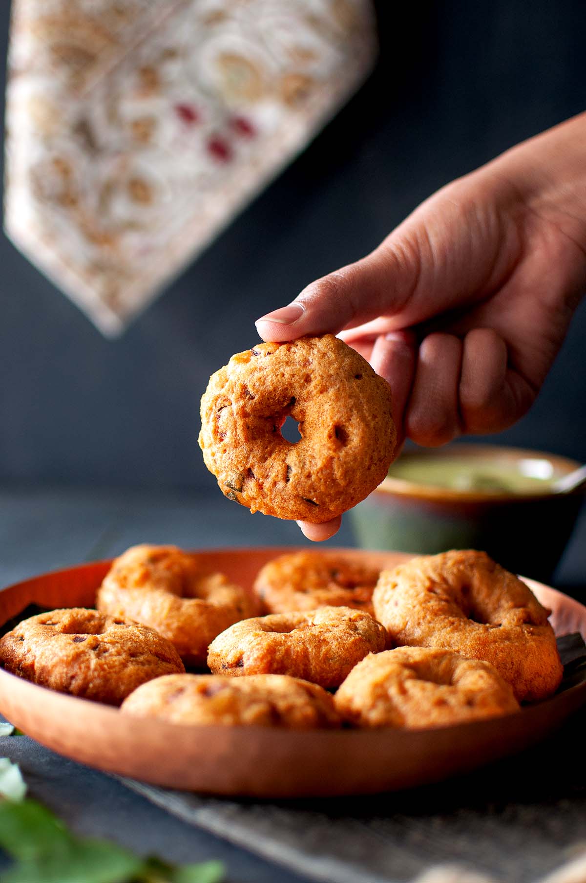 Hand holding an Urad dal Vada.