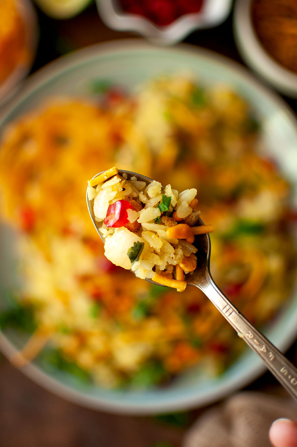 Spoon holding poha upma.